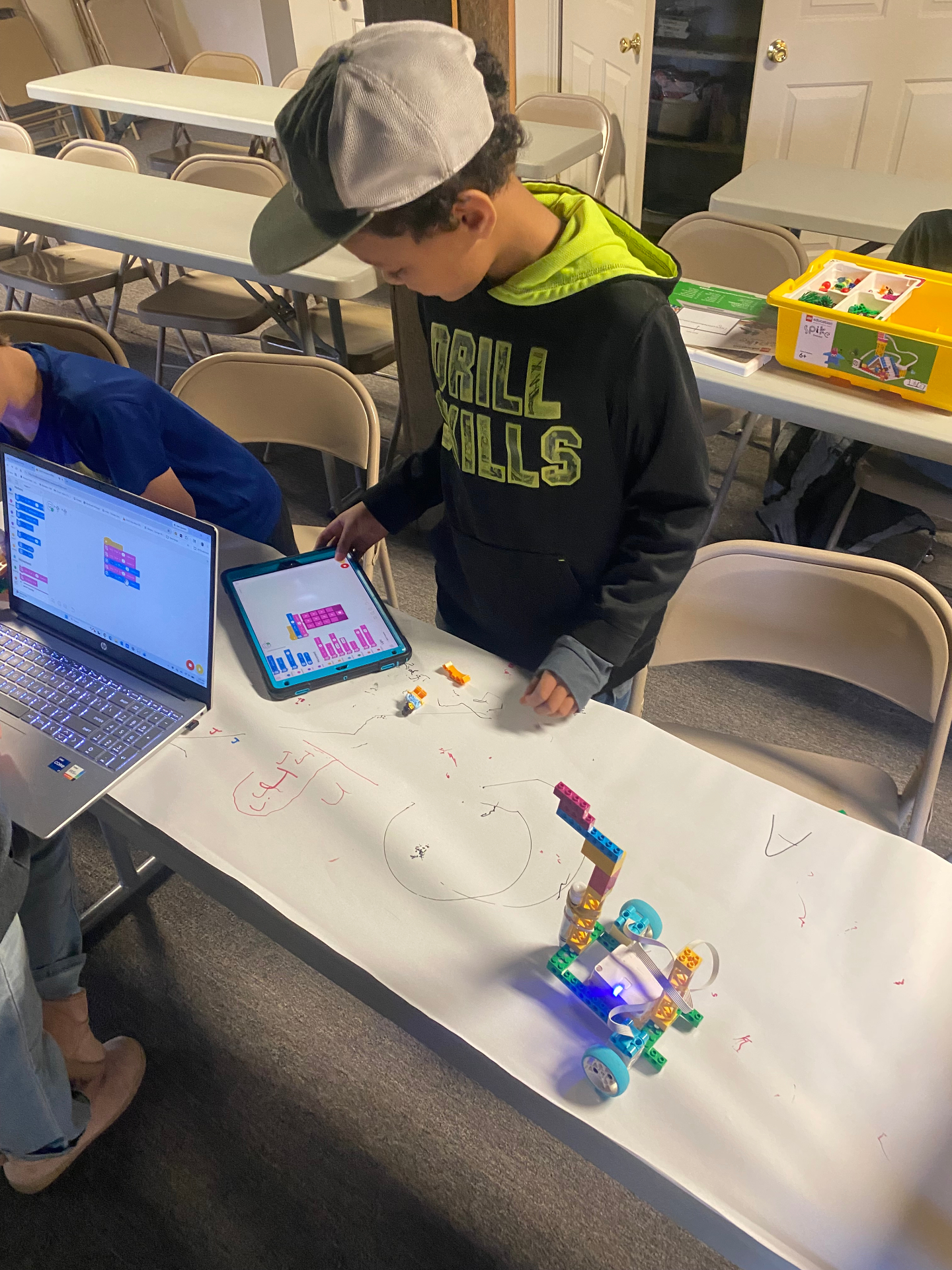 Young coder programming a LEGO robot with a tablet